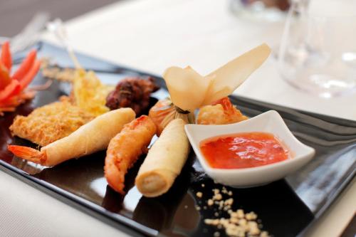 a black plate with food on a table at Cocca Hotel Royal Thai Spa in Sarnico