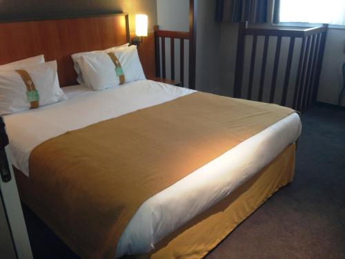 a large bed in a hotel room at Holiday Inn Calais-Centre by IHG in Calais