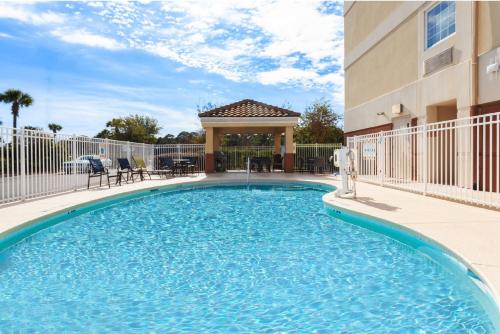 a swimming pool in front of a building at Candlewood Suites Destin-Sandestin Area by IHG in Destin