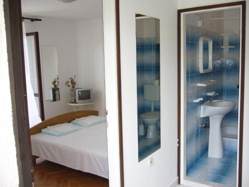 a bedroom with a bed and a sink and a mirror at Apartments Barić in Trogir