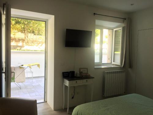 1 dormitorio con cama, ventana y TV en B&B MonteCengio, en Trieste