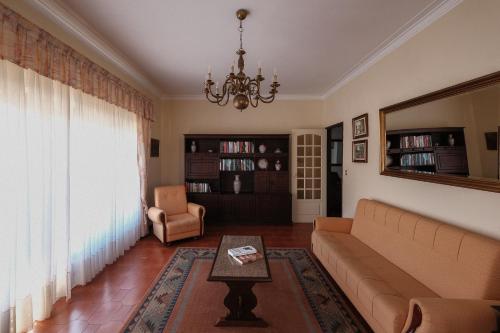 a living room with a couch and a chandelier at Home of pilgrims d`Apúlia in Apúlia