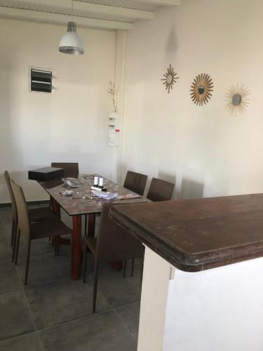 a dining room with a wooden table and chairs at Belcourt1-lit queen size in Baie-Mahault