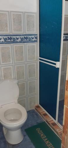 Łazienka z białą toaletą i niebieskimi drzwiami w obiekcie Hospedaje Rural Amanecer Llanero w mieście Restrepo