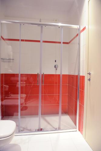 a glass shower in a bathroom with a toilet at Hotel Lis in Asti