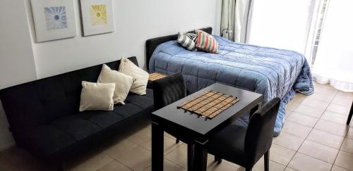 a living room with a couch and a table and a bed at Puerto Madero con Amenities in Buenos Aires