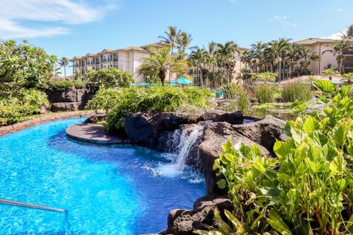 einen Pool mit Wasserfall in einem Resort in der Unterkunft Waipouli Beach Resort in Kapaa