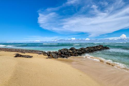 un grupo de rocas en una playa cerca del océano en Waipouli Beach Resort, en Kapaa