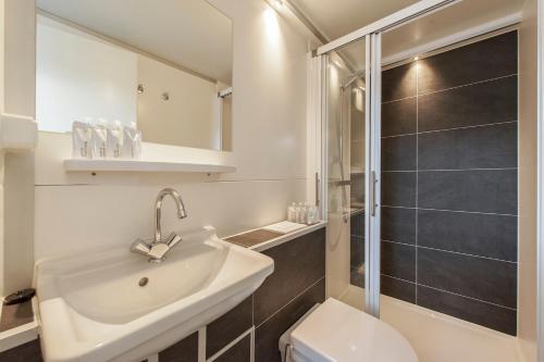 Tiny floating house Ibiza في ماستريخت: حمام مع حوض ودش ومرحاض