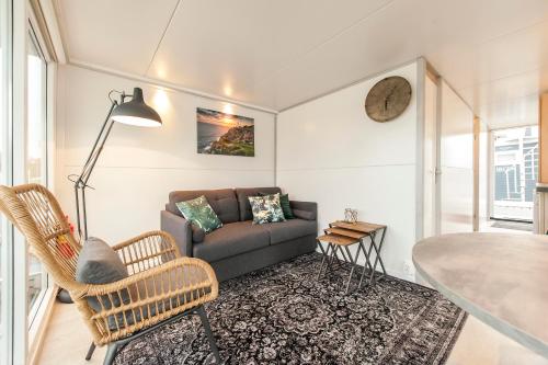 een woonkamer met een bank en een tafel bij Tiny floating house Ibiza in Maastricht