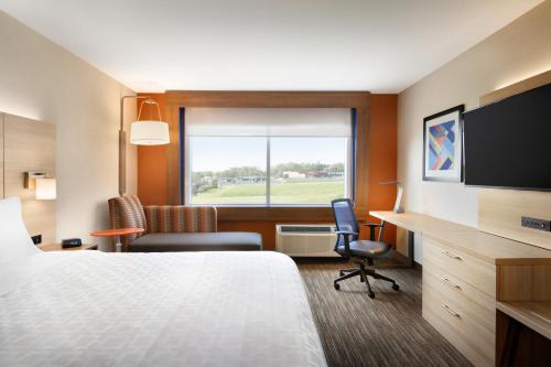 ein Hotelzimmer mit einem Bett, einem Schreibtisch und einem Fenster in der Unterkunft Holiday Inn Express & Suites - Yorkville, an IHG Hotel in Yorkville