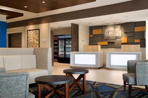 a lobby with two chairs and a couch and tables at Holiday Inn Express & Suites - Yorkville by IHG in Yorkville