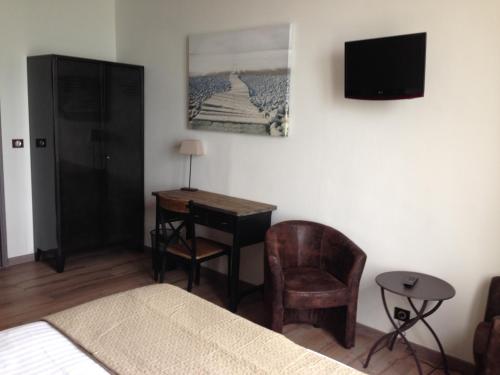 a bedroom with a bed and a desk and a television at Les Fregates in Veulettes-sur-Mer