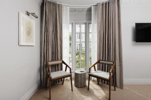 a living room with two chairs and a window at Palihotel Westwood Village - West Beverly Hills in Los Angeles