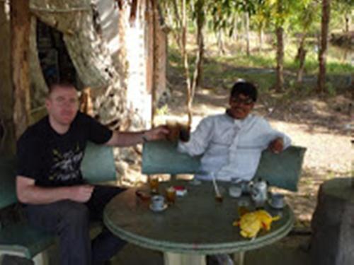 two men sitting at a table in front of a table at Minh Anh Garden Hotel in Mui Ne
