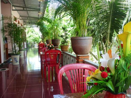 a restaurant with red chairs and potted plants at Minh Anh Garden Hotel in Mui Ne