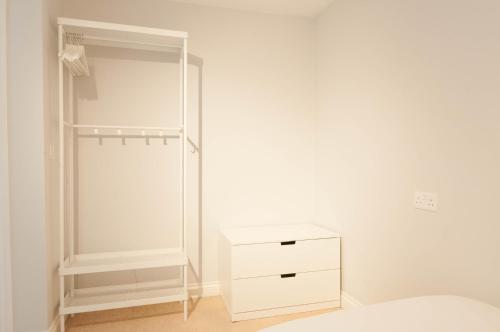 ein Schlafzimmer mit einem weißen Schrank und einer weißen Kommode in der Unterkunft Atlas House - Ideal for Contractors or Derby County Fans in Derby