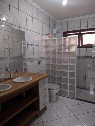 a bathroom with two sinks and a toilet in it at iUP HOUSE Hostel in Blumenau