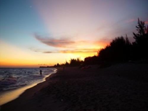 a person walking on the beach at sunset at Minh Anh Garden Hotel in Mui Ne