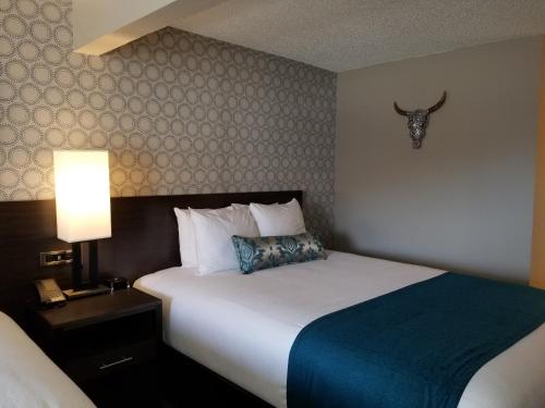 a hotel room with a bed and a bull skull on the wall at The Hotel Y in Yakima