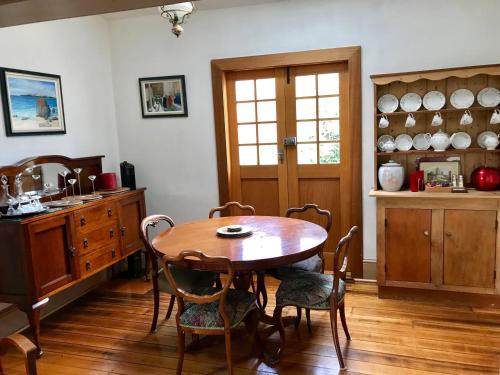 a dining room with a wooden table and chairs at Eliza cottage in Hobart