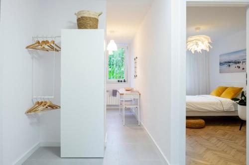Pokój z białymi ścianami i sypialnią z łóżkiem w obiekcie CRISTINE APARTMENT w Warszawie