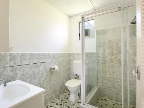 a bathroom with a toilet and a sink and a shower at Kendalls Beach Break in Kiama