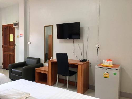 ein Zimmer mit einem Schreibtisch, einem Stuhl und einem Fernseher in der Unterkunft Pantip Residence in Nan