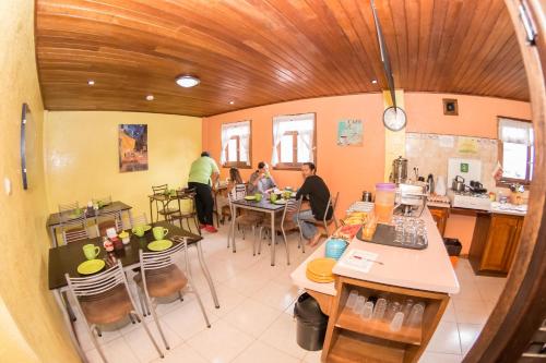 a group of people sitting at tables in a kitchen at La Casa del Molino Blanco B&B in Baños