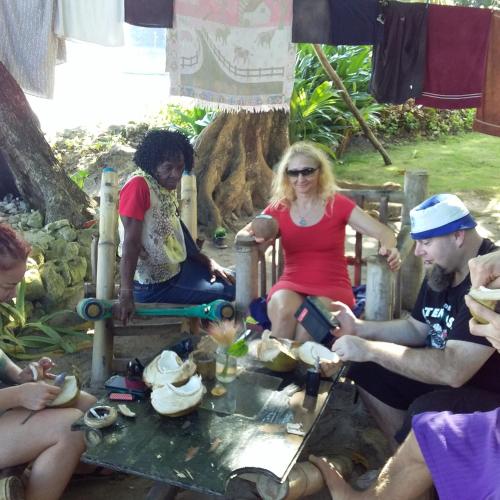 a group of people sitting around a table under a tree at Port Antonio Brian's Beach House in Port Antonio