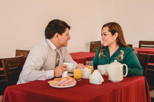 a man and a woman sitting at a table at Gran Hotel Guisama in Cajamarca