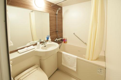 a bathroom with a sink and a toilet and a shower at Sotetsu Fresa Inn Nagoya Sakuradoriguchi in Nagoya