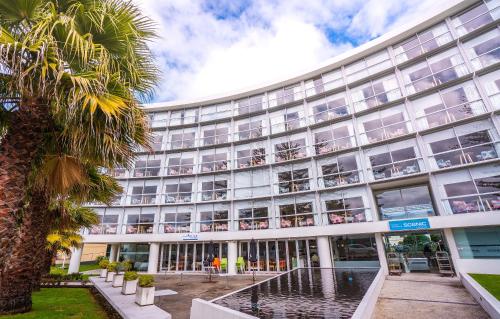 a large building with a palm tree in front of it at Scenic Hotel Te Pania in Napier