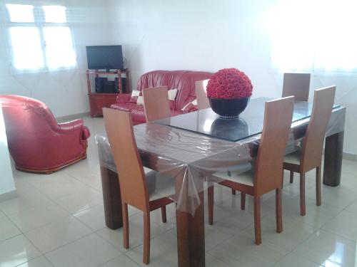 a dining table with chairs and a bowl of flowers on it at Villa Le Balisier in Le Lamentin