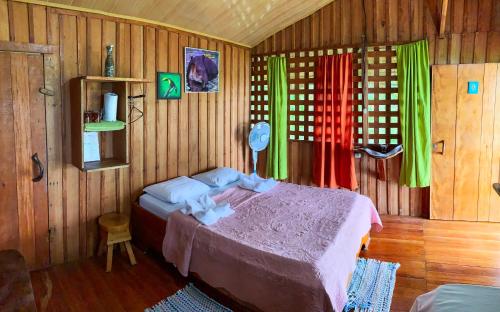 a bedroom with a bed in a room with wooden walls at Sunset Lodge in Drake