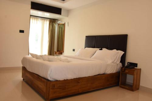a bedroom with a large bed with white sheets and a window at Wanderers Howff in Port Blair