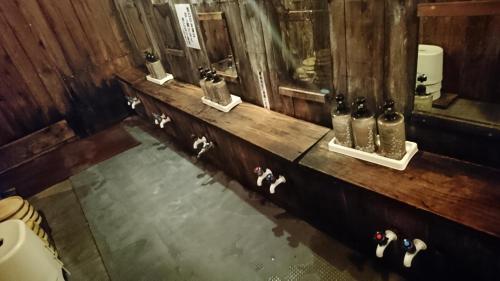 a bathroom with a counter with a sink and a mirror at Yachi Onsen in Towada
