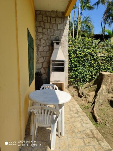 a table and two chairs sitting next to a oven at Pousada TRUFFIMAR Ilhabela in Ilhabela
