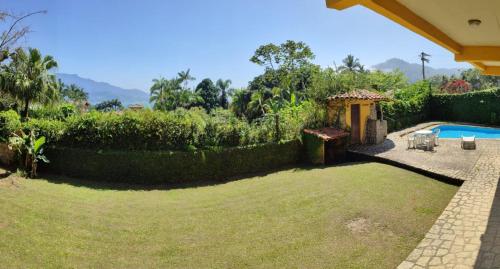a backyard with a swimming pool and a garden at Pousada TRUFFIMAR Ilhabela in Ilhabela
