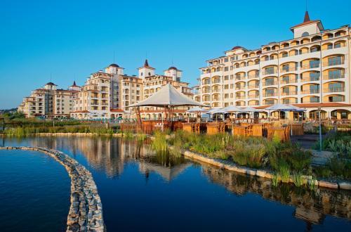 a large building next to a body of water at Sunrise All Suites Resort- All Inclusive in Obzor