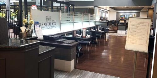 a restaurant with a bar with chairs and a staircase at Best Western Plus Village Park Inn in Calgary