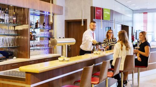 a group of people standing at a bar at Hotel Löwengarten in Speyer