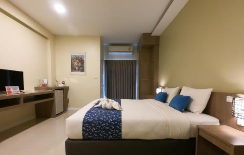 a bedroom with a bed and a desk and a television at It's me Keawanong Hotel in Nakhon Ratchasima