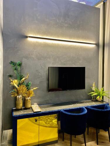 a living room with a yellow table and blue chairs at Noble Boutique Hotel - Adults Only in Budapest