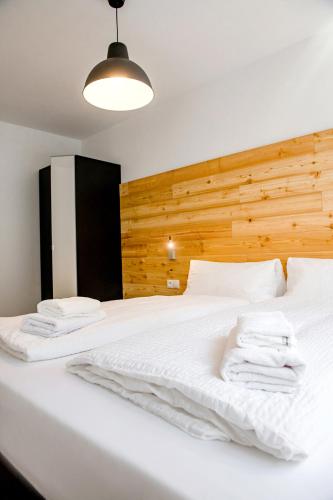 a bedroom with a white bed with a wooden headboard at Fischer Ferienhaus in Tweng