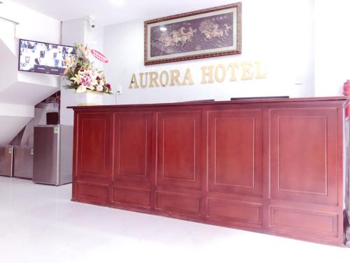 a wooden door in a building with a sign that reads aurora hotel at Aurora Hotel in Ho Chi Minh City
