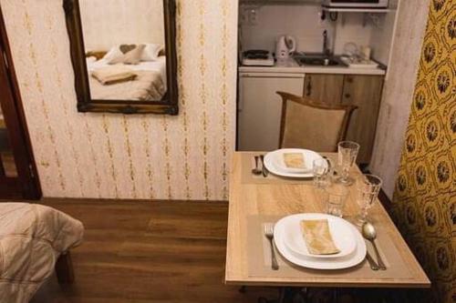 a table with two plates of food and a mirror at Boki Apartmant in Subotica