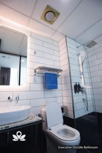 a bathroom with a toilet and a sink at Ceria Hotel in Kuala Lumpur