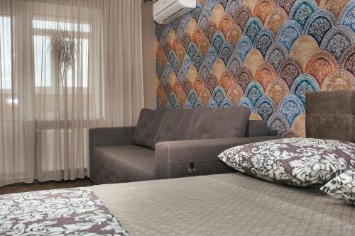 salon z kanapą i kolorową ścianą w obiekcie Luxury apart-hotel near Lavina New Building 7 floor w mieście Sumy
