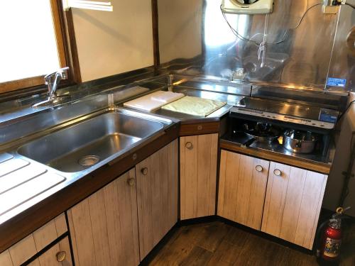 a kitchen with a sink and a stove at Cool-Cottage Otaru OTAMOI in Otaru